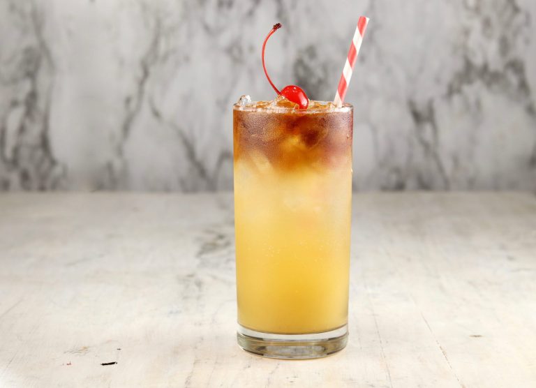 Pineapple Rum cocktail with a straw made with black spiced rum
