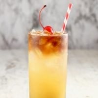 Pineapple Rum Punch with cherry and straw