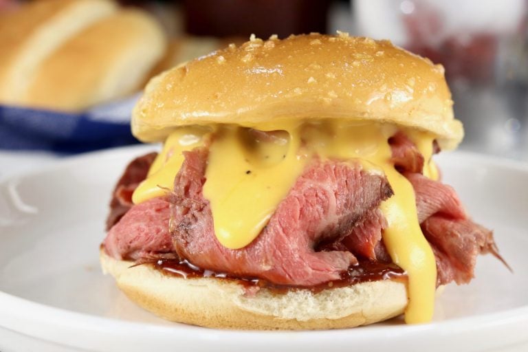 Cheddar cheese sauce topped roast sandwich on a bun