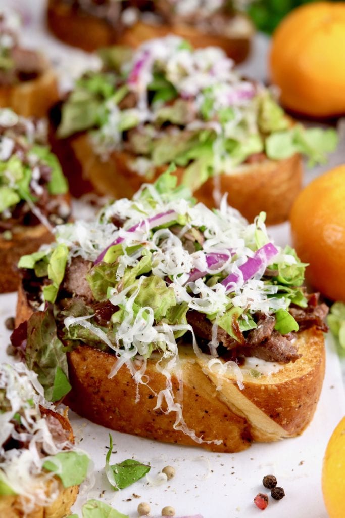 Garlic toast sandwich with steak, lettuce, red onion, and parmesan