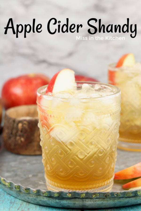 Glass of apple cocktail with beer garnished with fresh apple slice