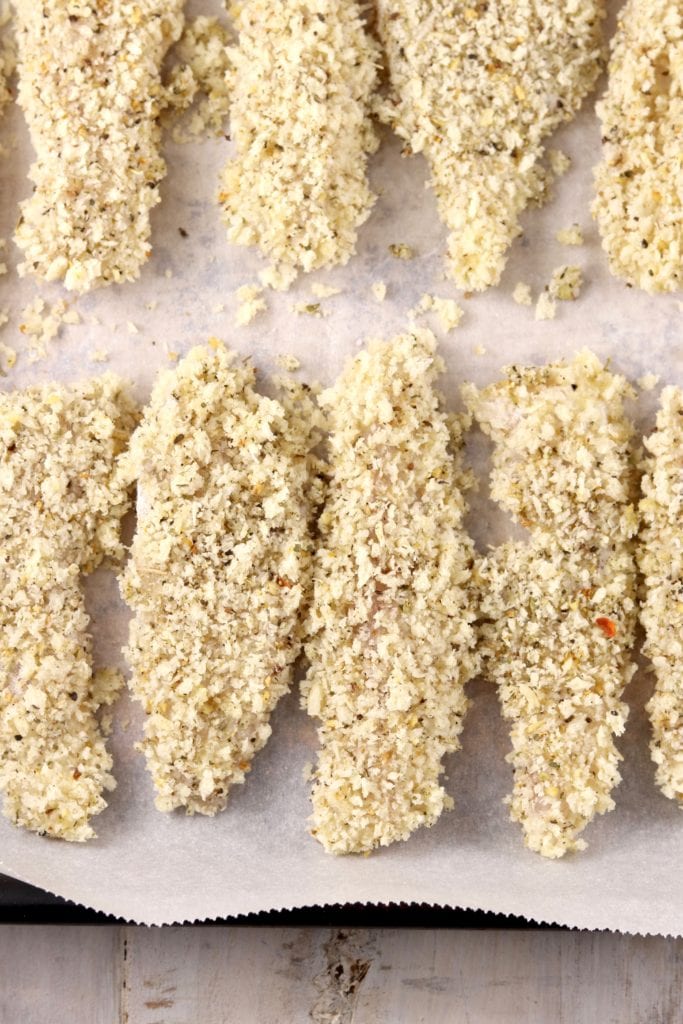 Panko breaded fish sticks on a baking sheet before baking
