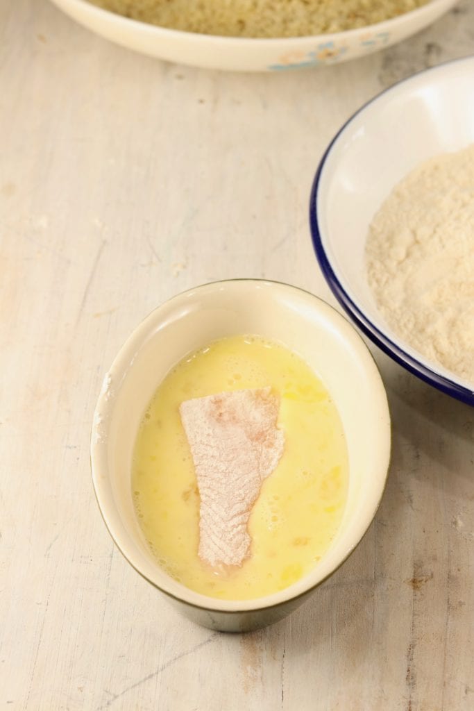Breading fish sticks into egg wash