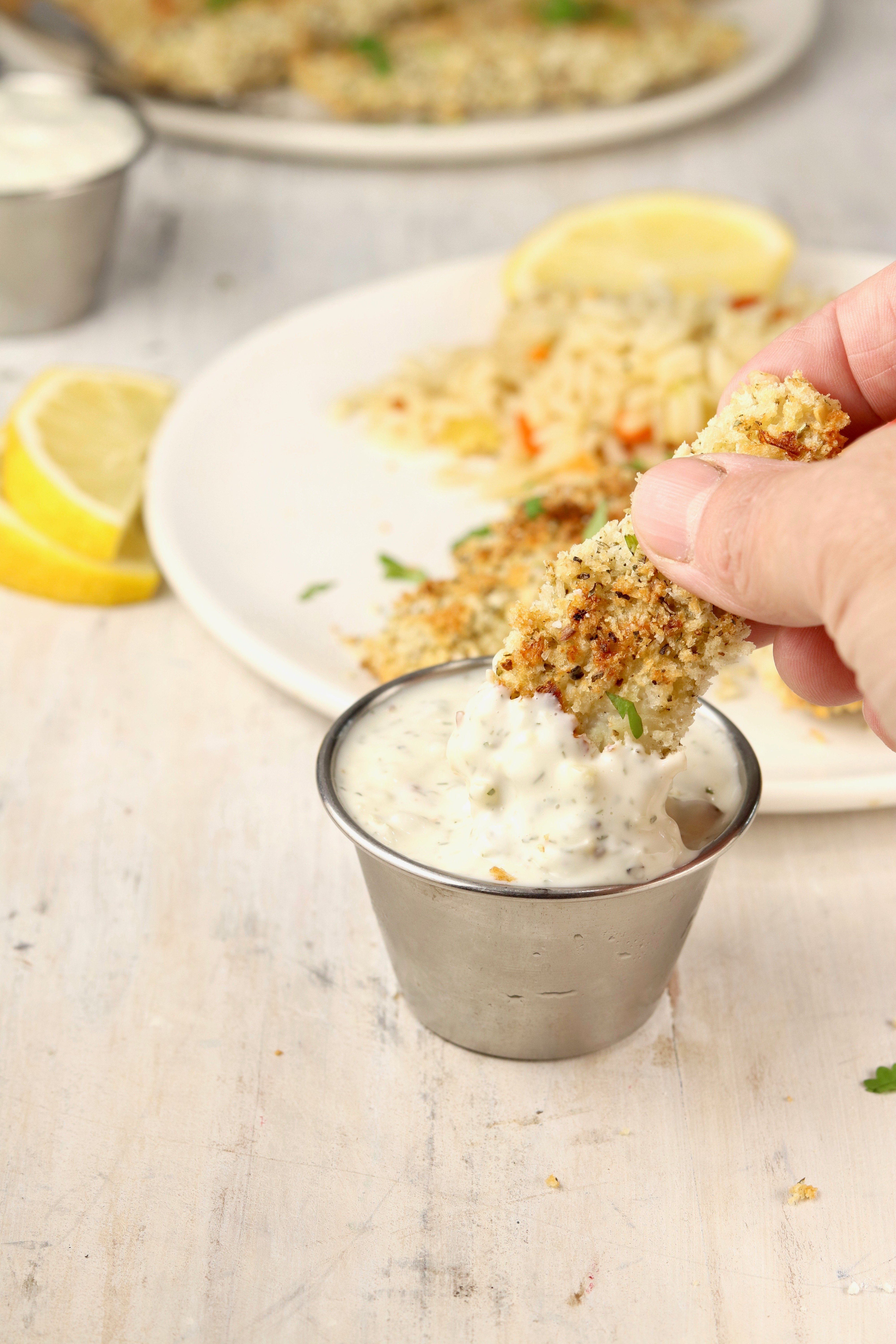 Fish Stick dipping in tartar sauce.
