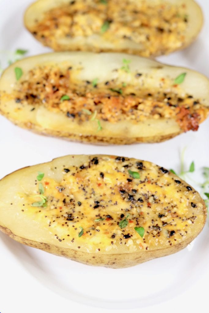 Grilled Potatoes with cheese and seasonings on a white platter