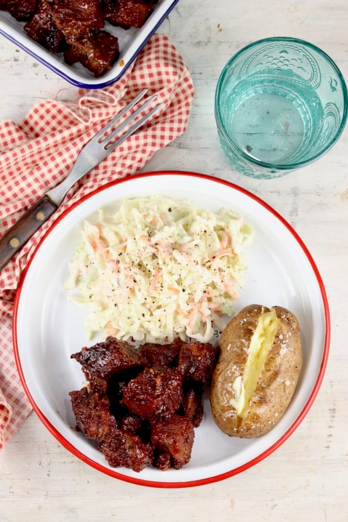 Plate of barbecue beef with slaw and baked potato