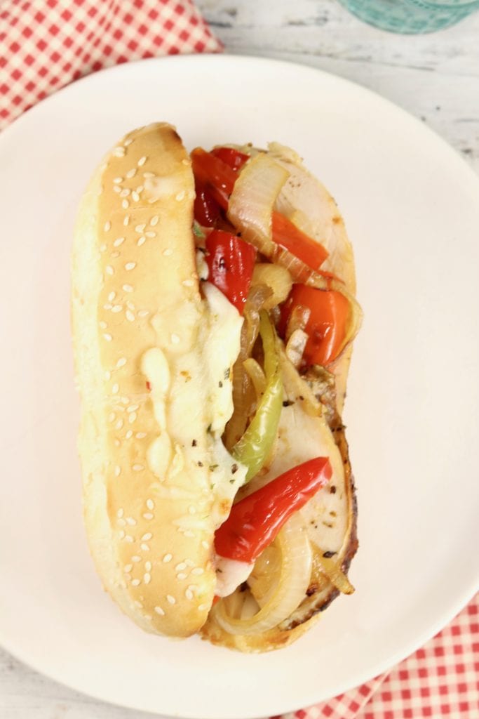 White plate with chicken sandwich on a sub roll