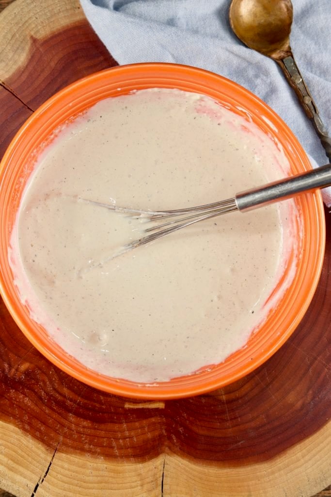 Orange bowl with horseradish sauce and flat whisk