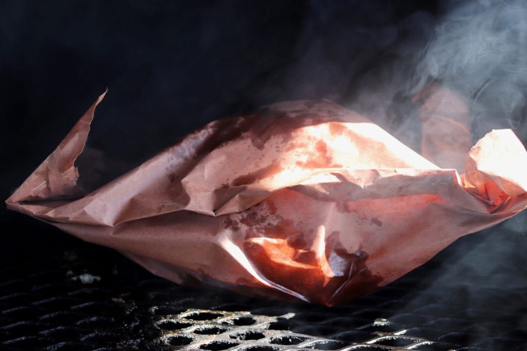Butcher paper wrapped turkey breast on grill