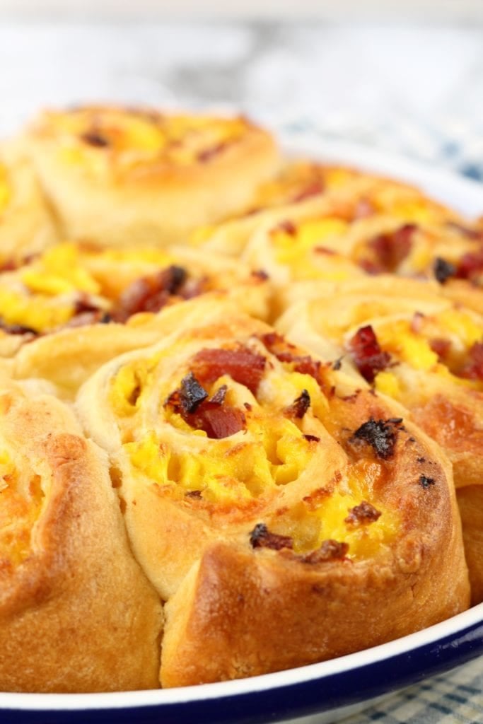 Ham and Egg Breakfast Rolls with cheese are the perfect breakfast for any morning of the week and a delicious addition to a holiday brunch. Just a few simple ingredients in this easy breakfast roll. Ham and Egg Breakfast Rolls in a white pie pan