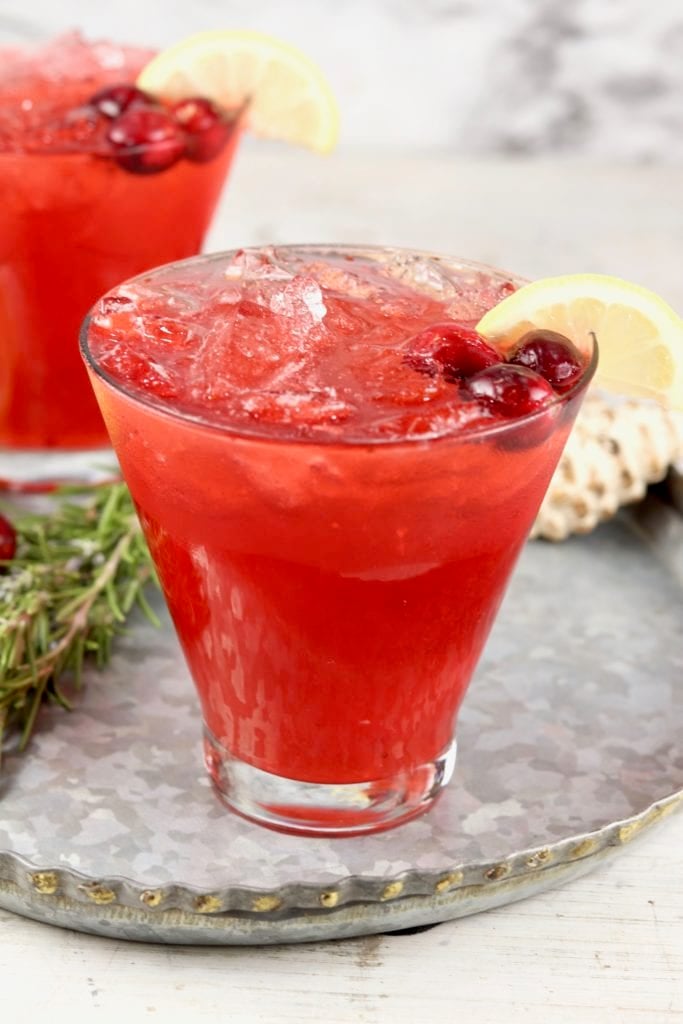 Cranberry cocktail in a cosmopolitan glass garnished with lemon