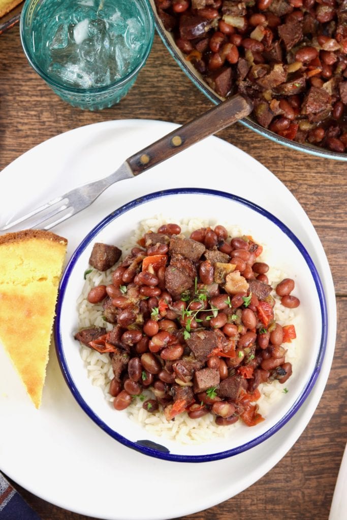 Plate of cornbread with bowl of red beans and rice