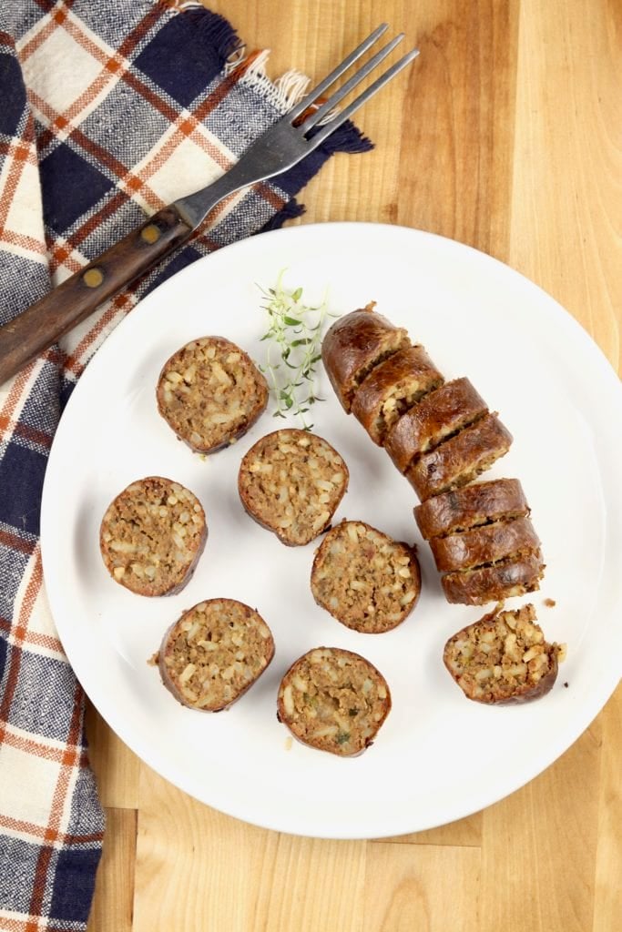 Sliced boudin sausage on a white plate