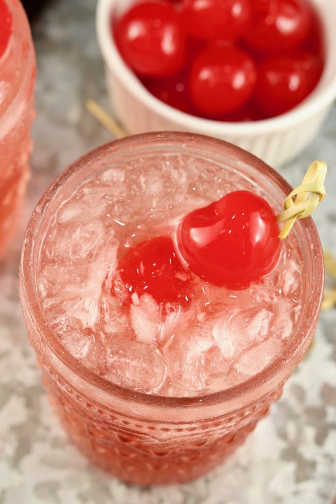 Cherry garnish on cranberry old fashioned cocktail