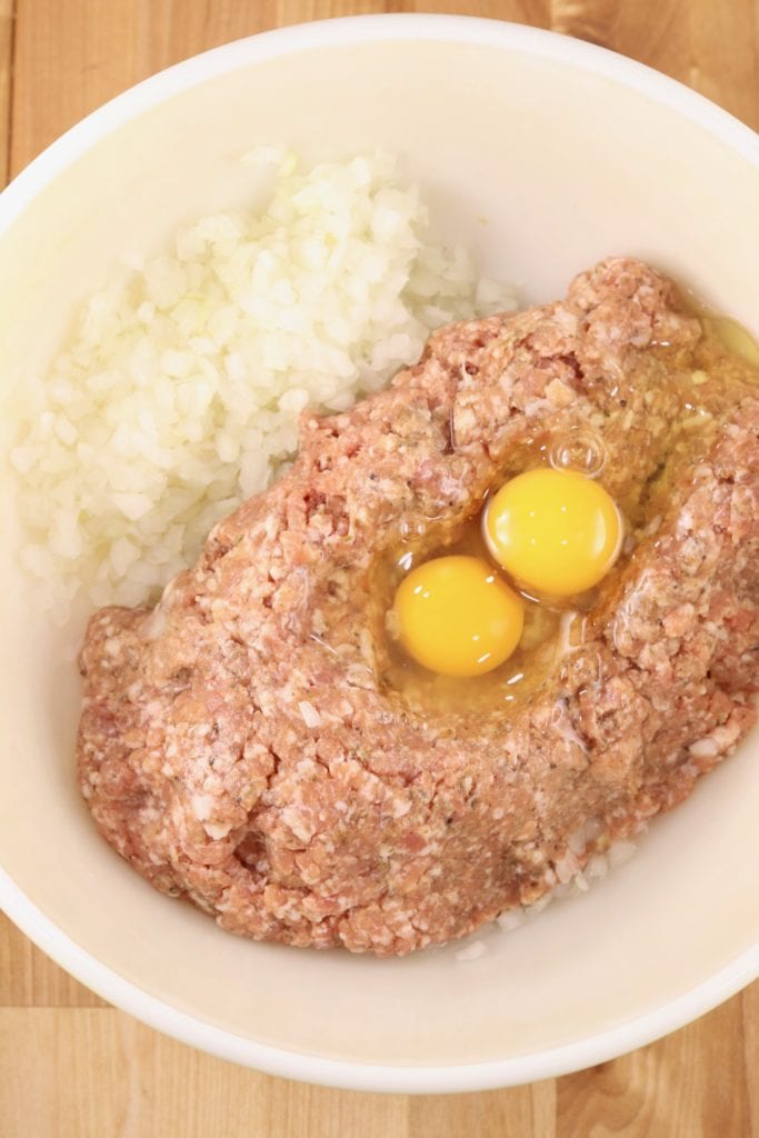 Mixing bowl with Italian Sausage, onions and eggs for meatballs
