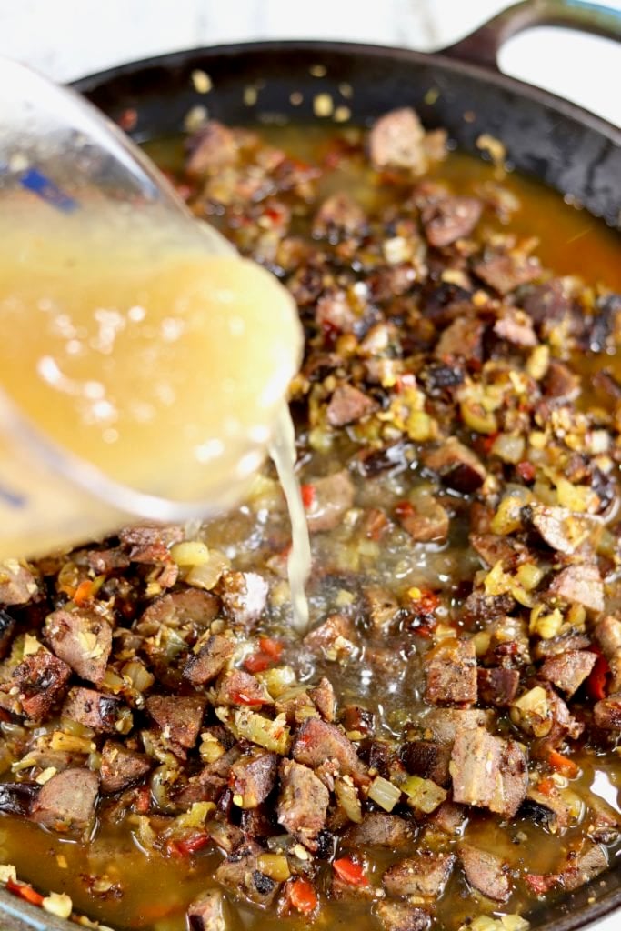 Adding broth to vegetables for shrimp gumbo