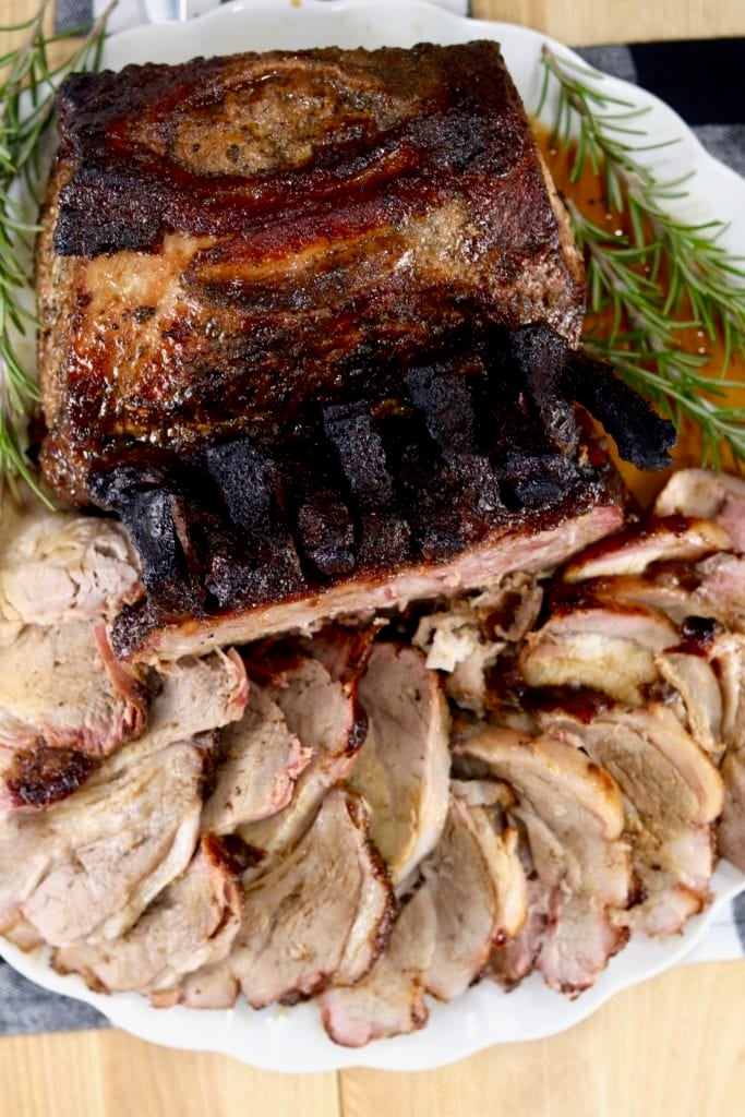 Double Pork Rib Roast on a platter with half of the roast sliced