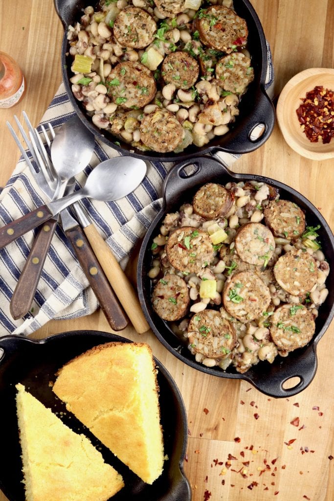 2 cast iron mini skillets of purple hull peas with cornbread
