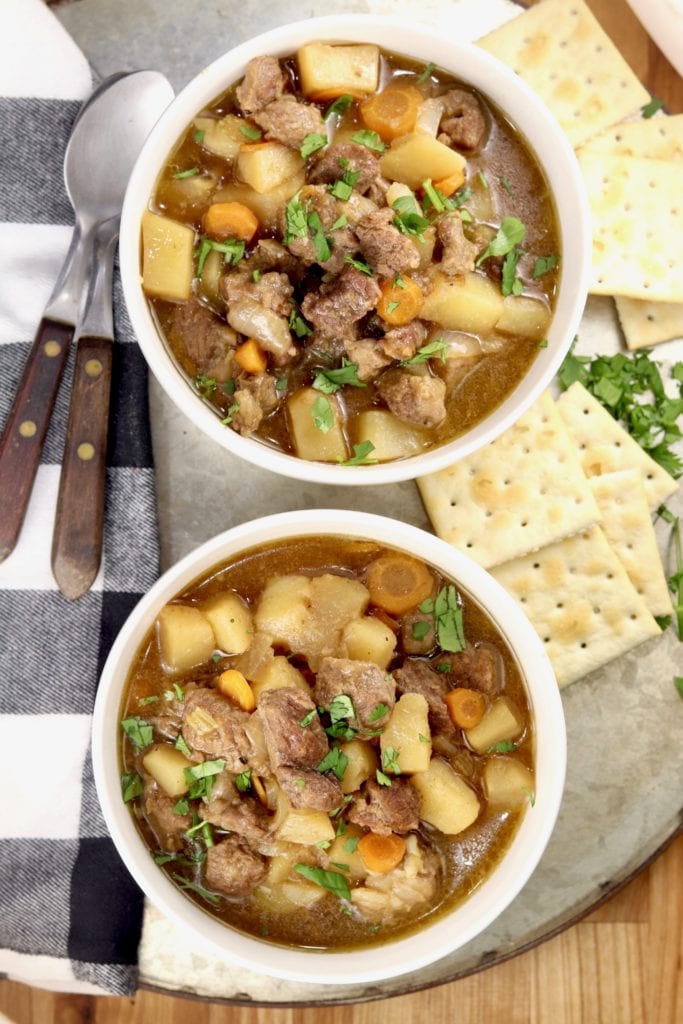 Beef vegetable stew - 2 bowls on a platter with crackers