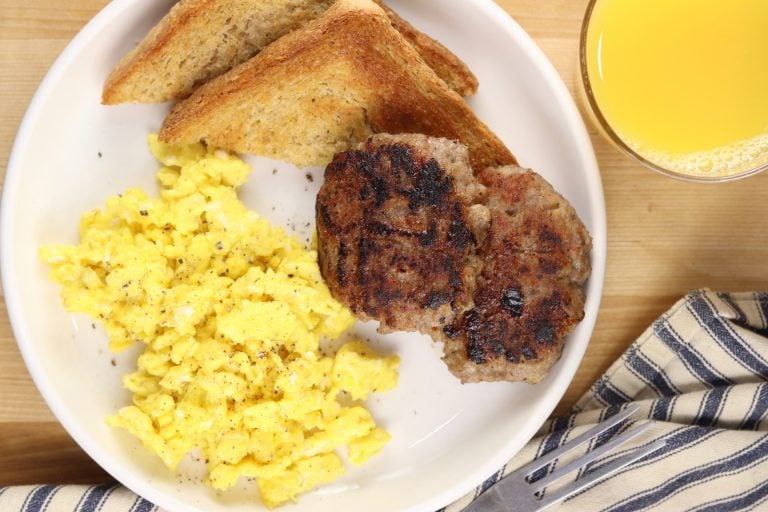 plate of scrambled eggs, sausage patties and toast