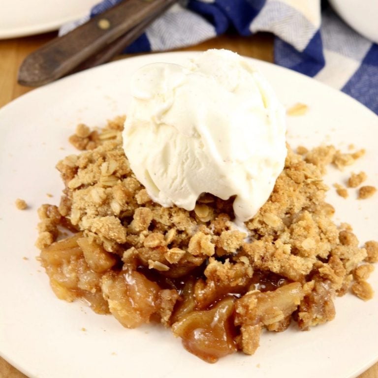 apple crisp with a scoop of vanilla ice cream on a small plate