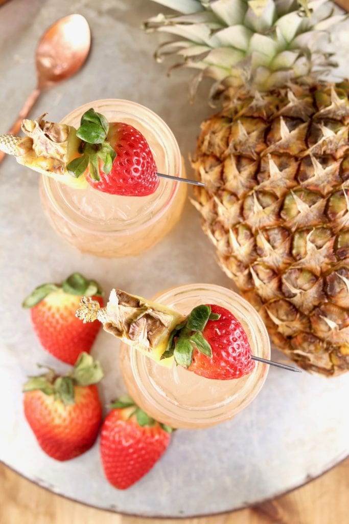 overhead view of wine cocktails garnished with pineapple wedges and strawberries