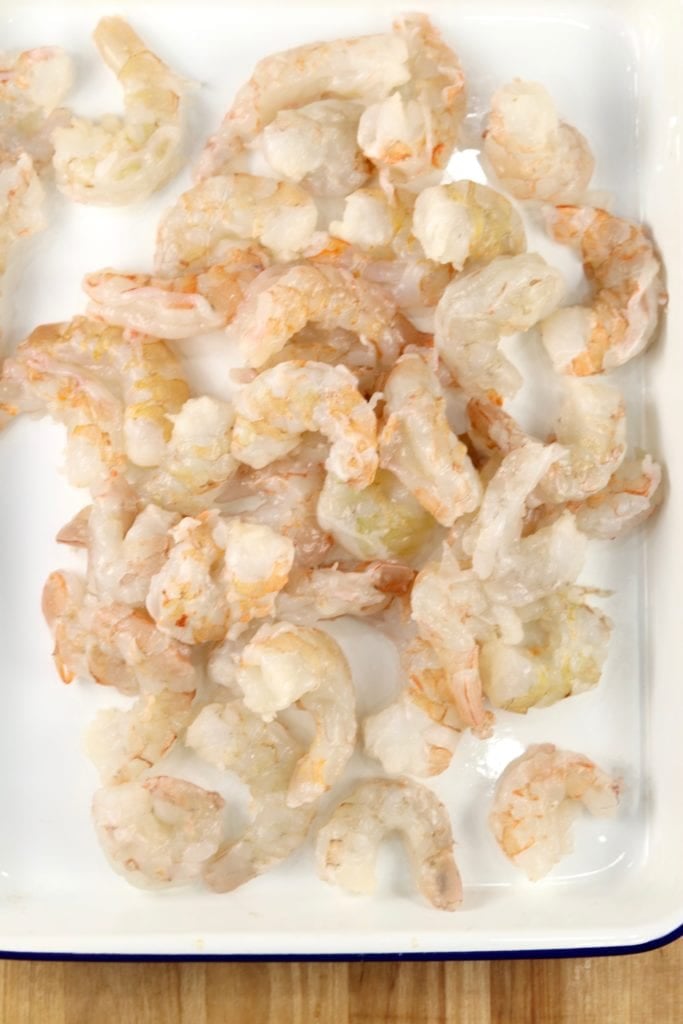 Raw Large shrimp, peeled on a white enameled baking dish