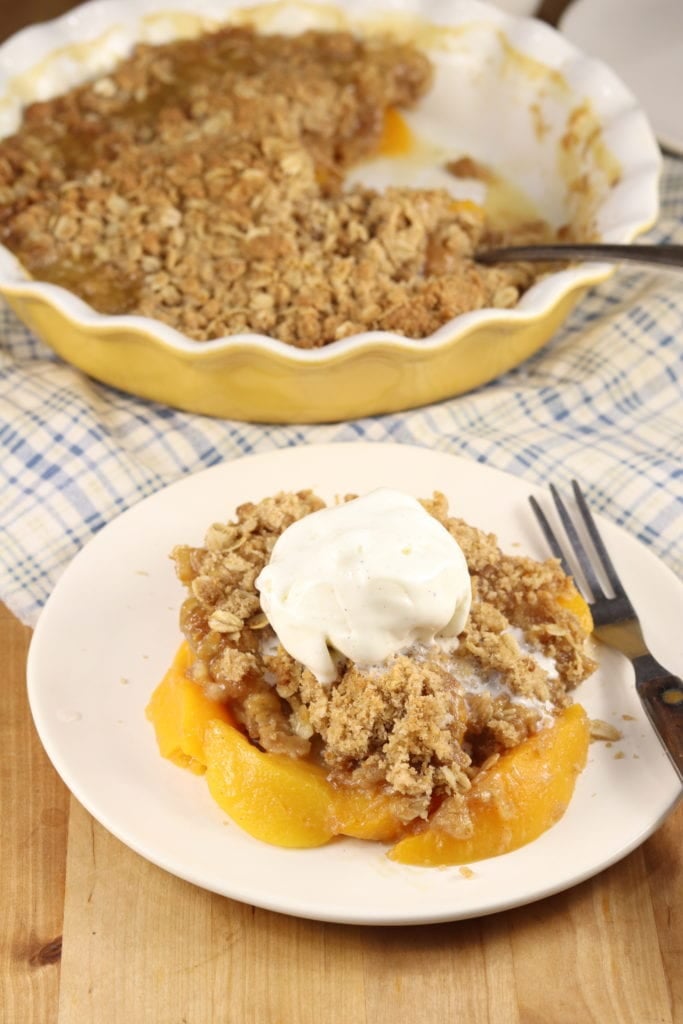 Peach Crisp is a delicious dessert filled with juicy peaches and topped with a crispy brown sugar, cinnamon and oat topping. Perfect for a quick and easy weeknight treat! Peach Crisp Recipe with vanilla ice cream