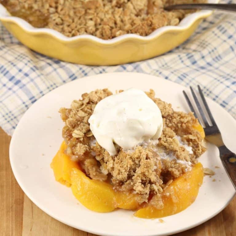 Plate of peach crisp with vanilla ice cream.