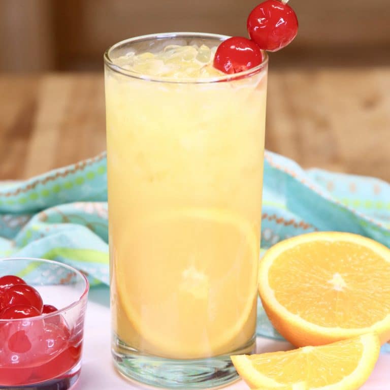 fuzzy screwdriver cocktail with orange slice and maraschino cherry garnish.