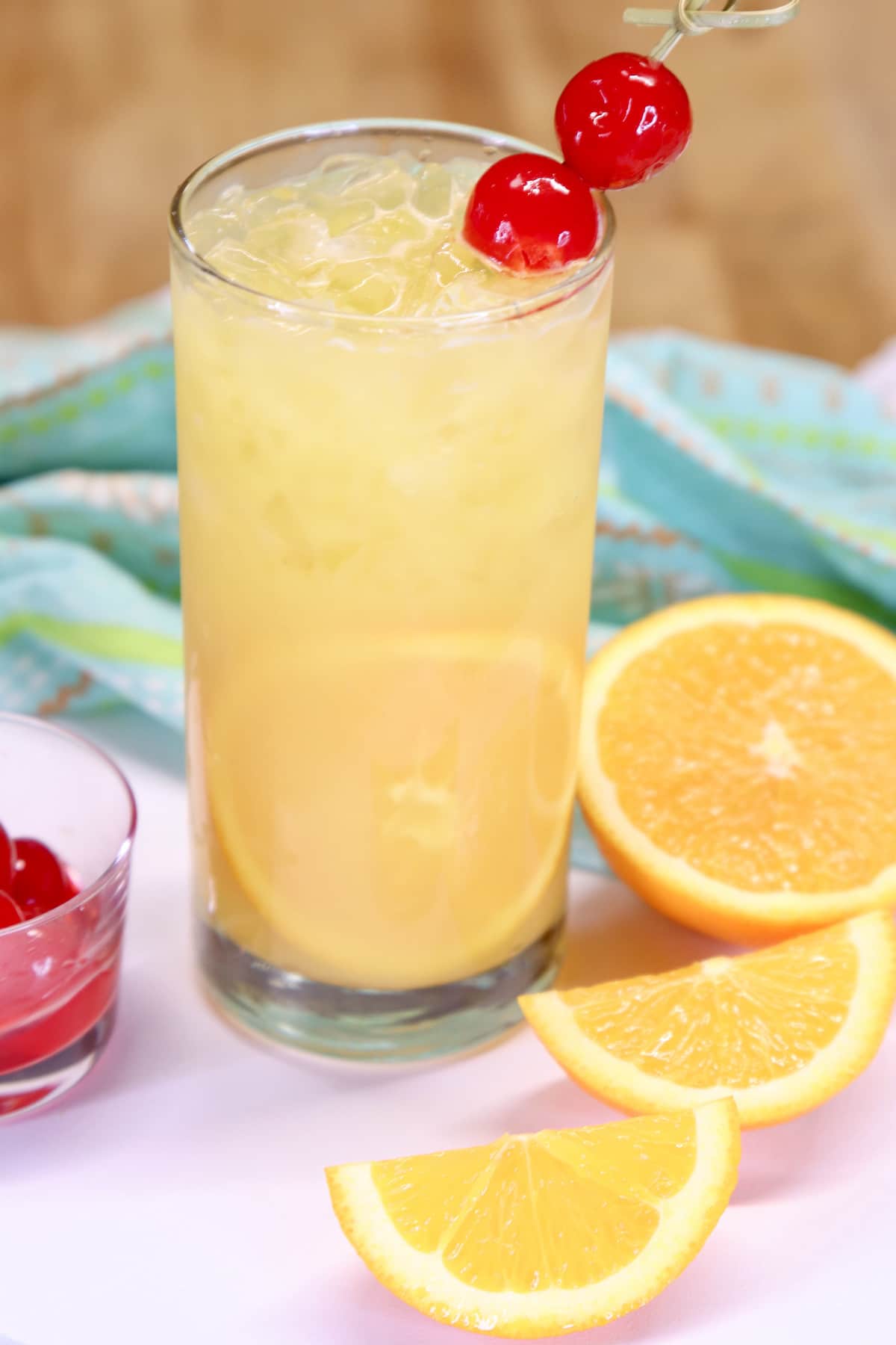 Fuzzy Screwdriver cocktail in a glass with orange slice and cherry garnish.