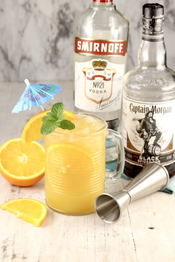 Brass Monkey Cocktail with vodka & rum bottles, jigger