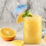 Brass Monkey Drink with orange, mint and umbrella garnish in a mug