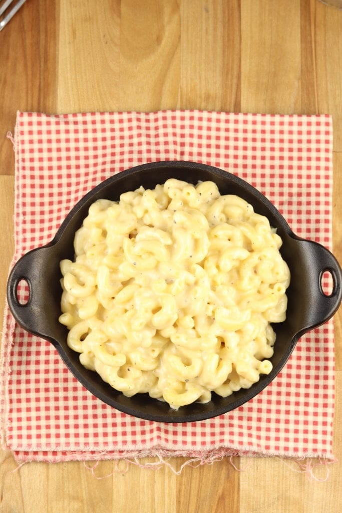 Mac and Cheese in a cast iron mini skillet with a red check napkin