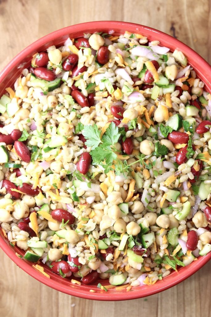 Beans, vegetables and pearl barley in a red bowl