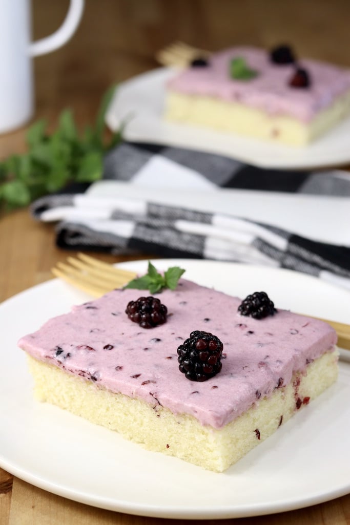 Blackberry sheet cake slices on white plates