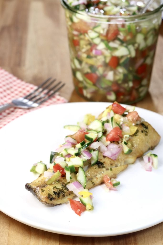 Chopped vegetable salad over fish filet