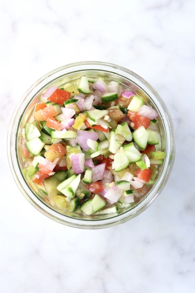 Chopped tomato, cucumber, onion salad in a jar