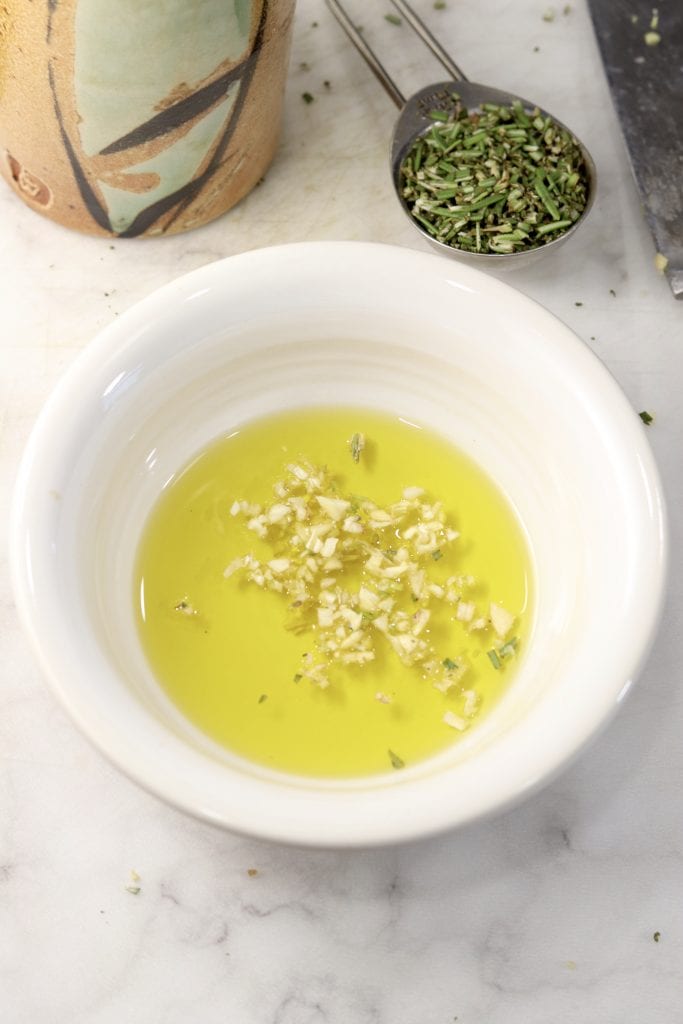 Minced garlic in olive oil in a white bowl