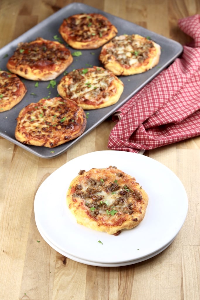 mini pizzas on a pan + one on a white plate.
