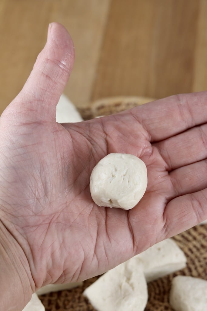 biscuit dough ball in palm of hand for donut holes
