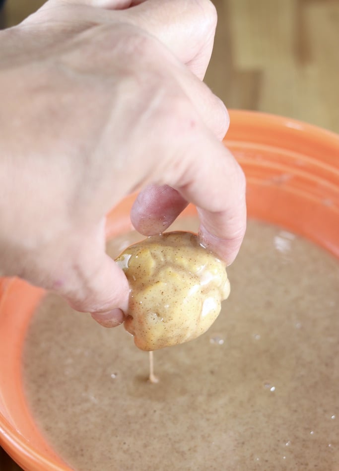 Dipping donut holes in maple glaze