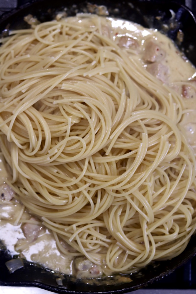 Spaghetti in a skillet over lemon sauce