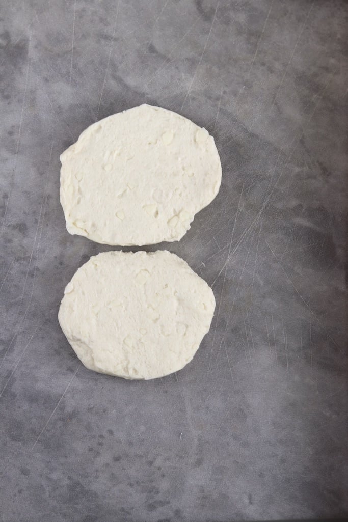 canned biscuits separated into 2 layers on a gray board