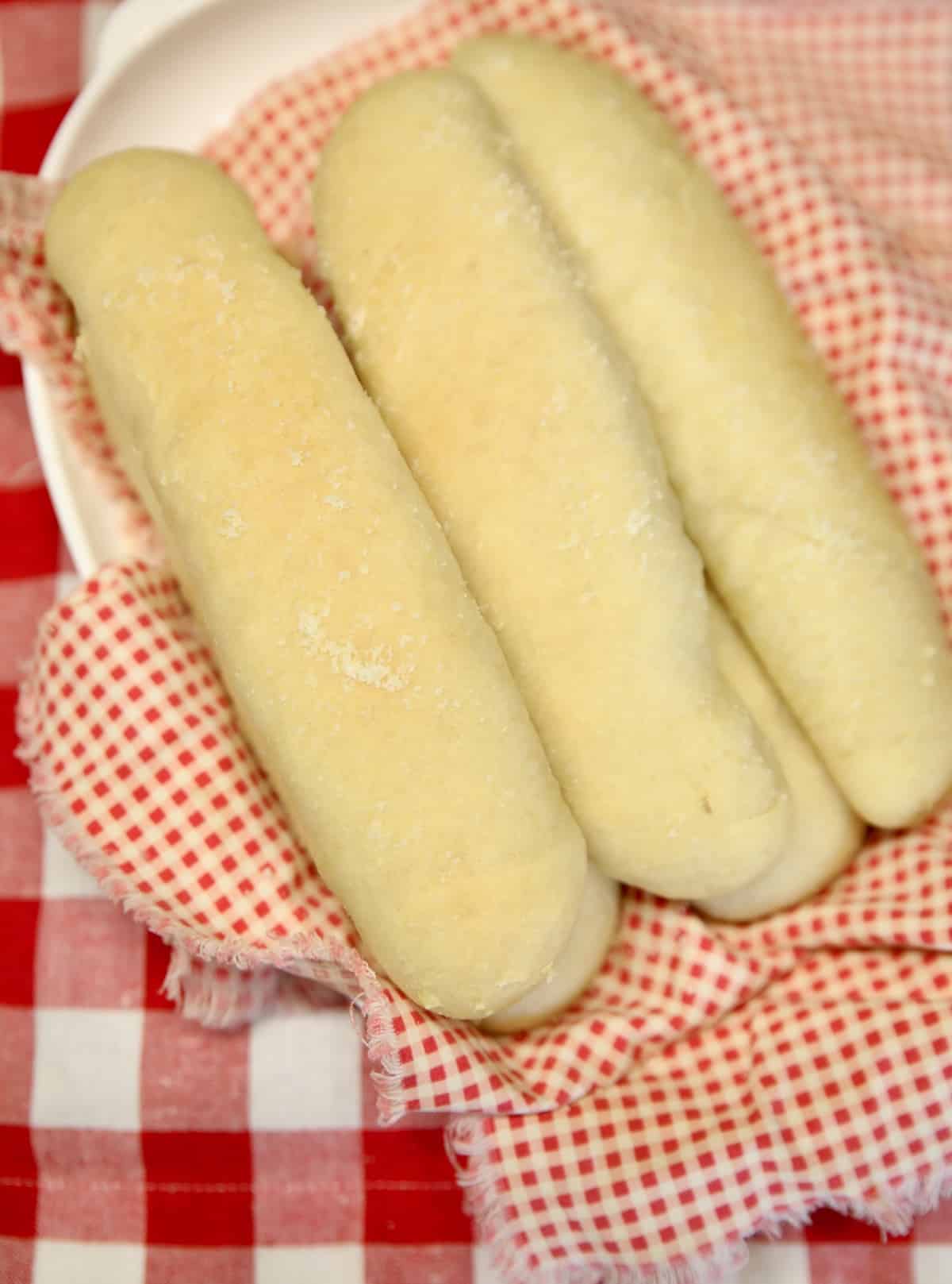 Soft Breadsticks that tastes like Olive Garden. Plate of breadsticks on red check napkin.