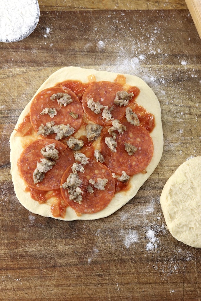 Mini biscuit pizza topped with pepperoni and sausage
