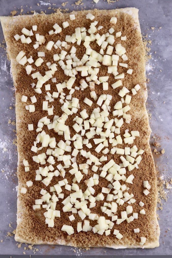 Crescent dough rectangle topped with brown sugar, cinnamon and diced apples