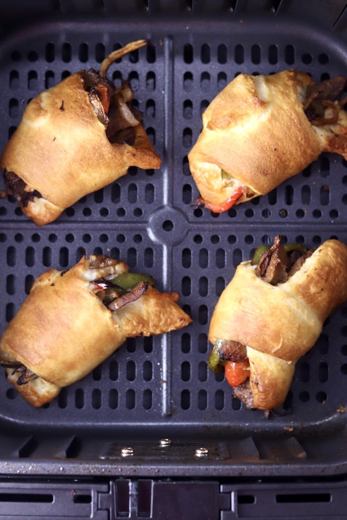 Air Fryer Cheesesteak Rolls in air fryer basket