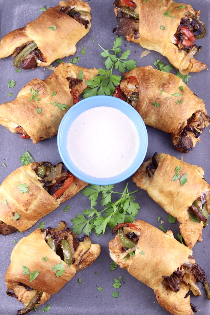 Air Fryer Cheesesteak Rolls with horseradish sauce on a platter