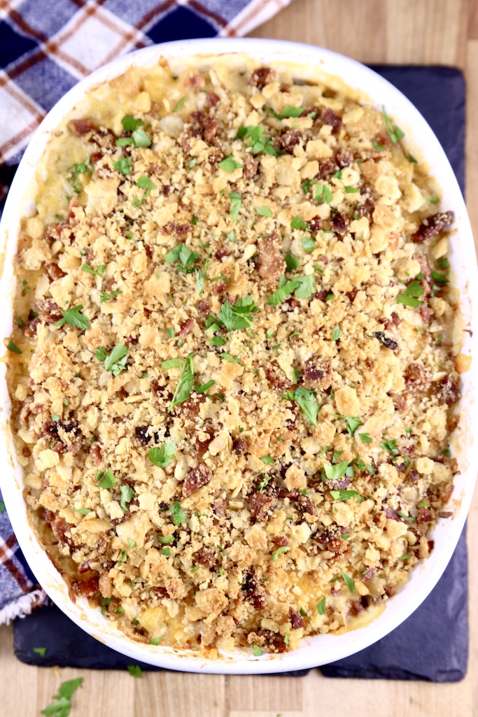 Broccoli and chicken and rice casserole topped with ritz crackers and bacon in an oval dish